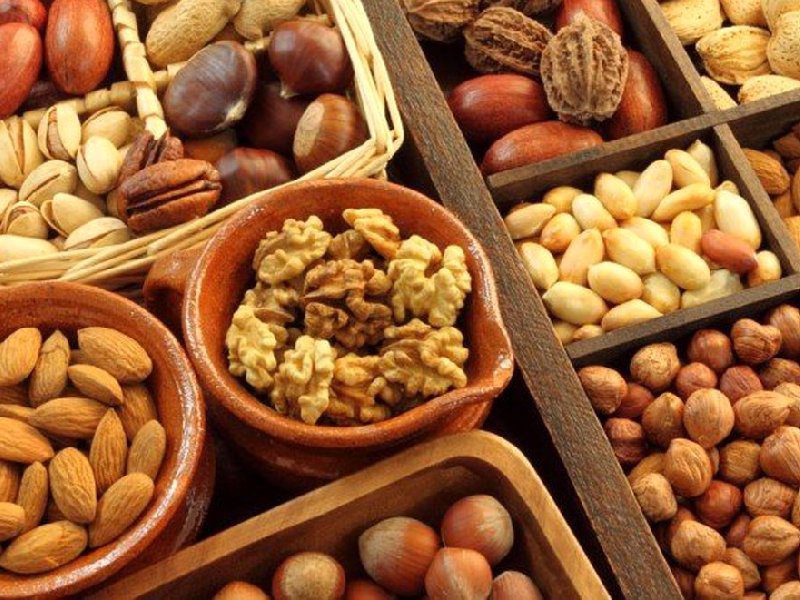 چند پیاله چوبی و سفالی که هر کدام از یک نوع آجیل و خشکبار پر شده است
