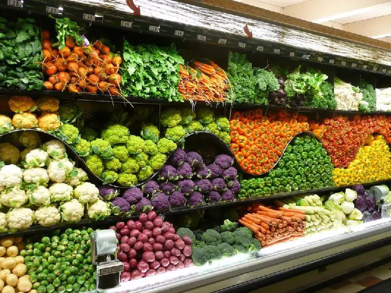 انواع میوه چیده شده در قفسه‌های مغازه میوه فروشی