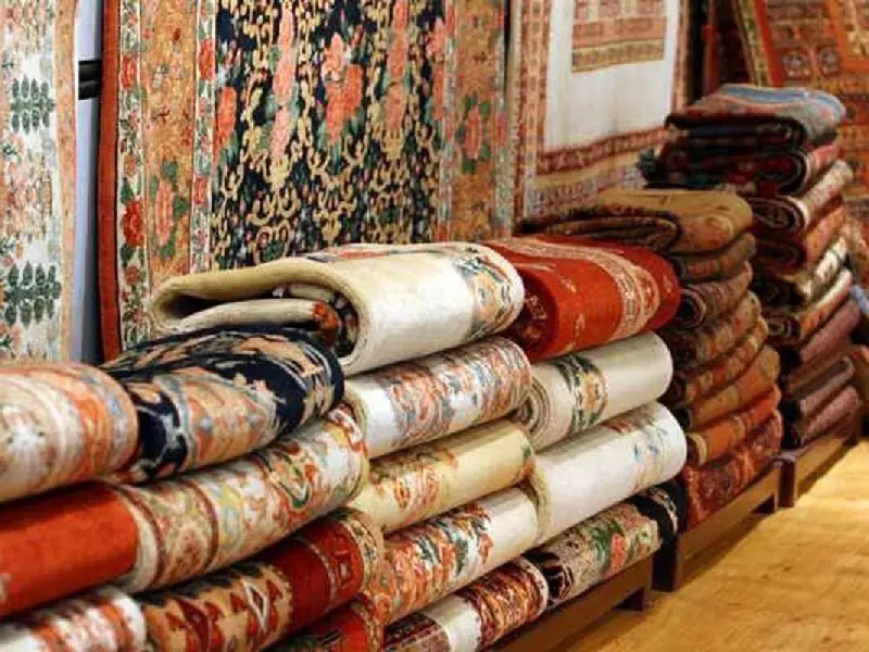 تعدادی فرش تا شده در مغازه فرش فروشی